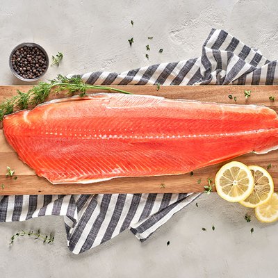 salmon filet with salt and lemon on cutting board