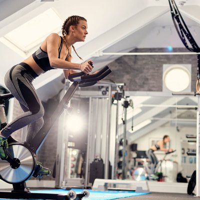 Woman using stationary indoor exercise bike for fitness