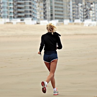 Woman running on the beach wearing women's workout shorts