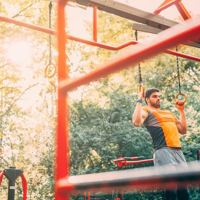 Man using rings for a playground workout.
