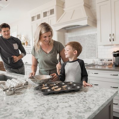 Family baking muffins in kitchen