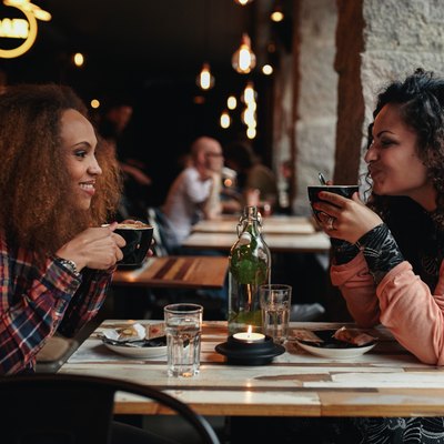 Two women talking and drinking coffee in a cafe