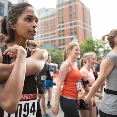 Woman stretching at the start line of a running race