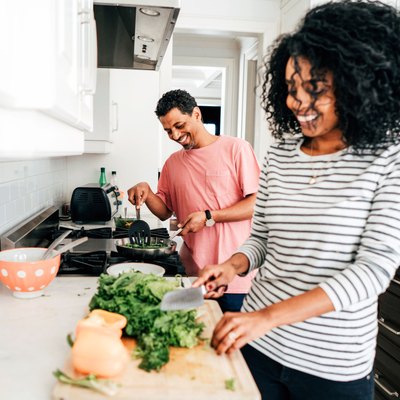 Couple using cooking tips and cooking hacks for healthy cooking in kitchen
