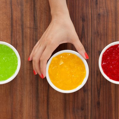 Woman's hand reaching for bowl of yellow Jell-O