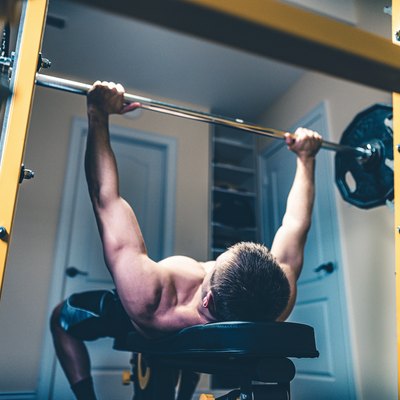 photo of man lifting weights doing bench press