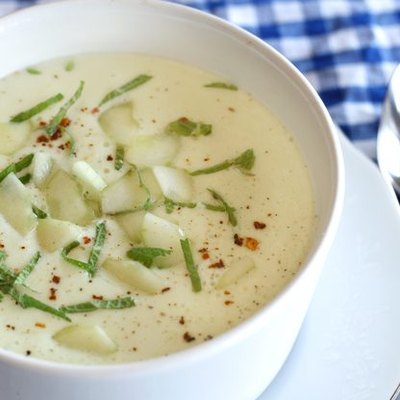 A bowl of white gazpacho with cucumber and avocado