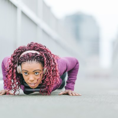 Determined sports woman doing push-ups in city