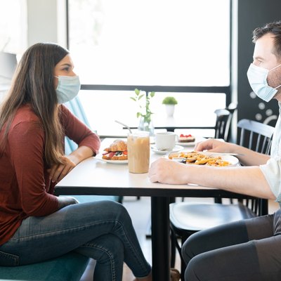 photo of Couple wearing Face Masks eating at a restaurant
