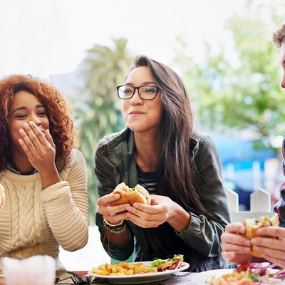 Friends eating burgers and trying to figure out how to stop overeating