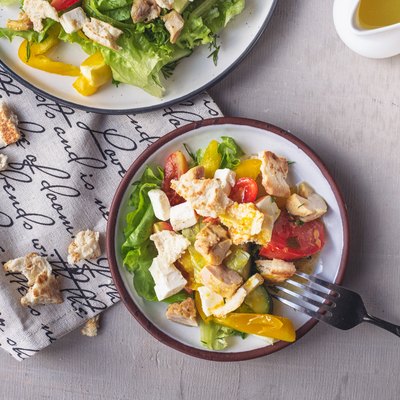 salad ingredients bowl with chicken, greens and veggies