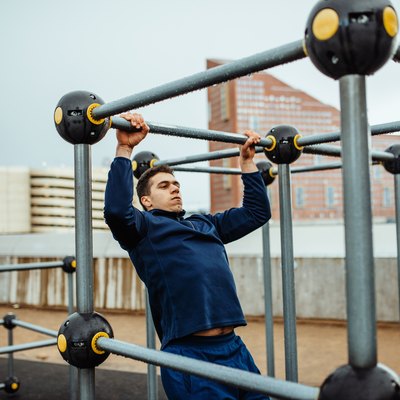 Man doing pull-ups outdoors as part of a CrossFit WOD