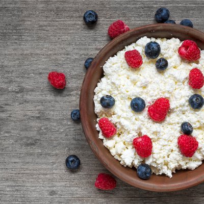 Cottage cheese with fresh raspberries and blueberries in a bowl for healthy breakfast