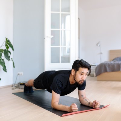 Asian man does planking exercise at home