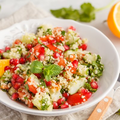 Tabbouleh salad with tomato, cucumber, couscous, mint and pomegranate. Vegan Healthy Food Concept. Traditional middle eastern or arab dish.