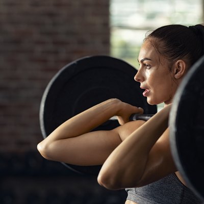 Woman doing weight lifting at cross fit gym