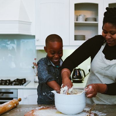 Mother and son mix dough for bread