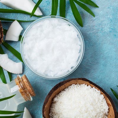 Set of organic coconut products for spa, cosmetic or food ingredients. Oil, water and shavings top view.