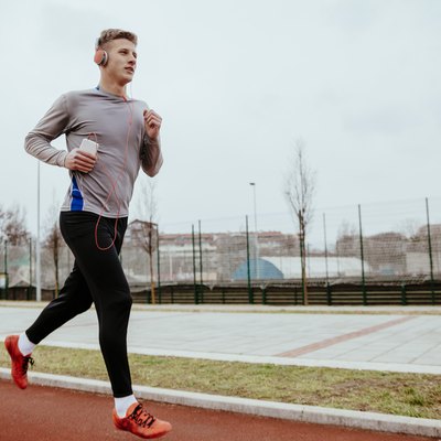 Young man running on tartan track