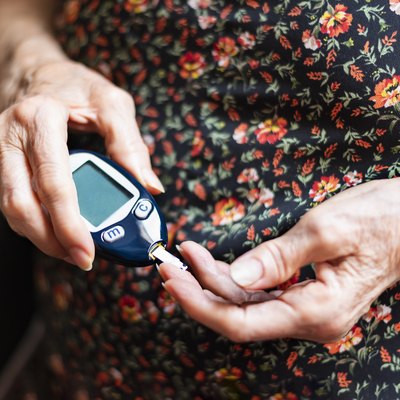 An older woman with type 2 diabetes checking her blood sugar