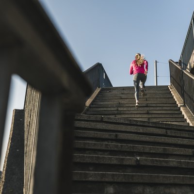 Young woman running up stairs
