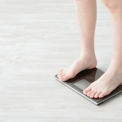 Woman getting on weight scale
