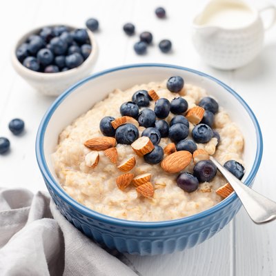 Healthy breakfast oatmeal porridge in bowl with blueberries and almonds