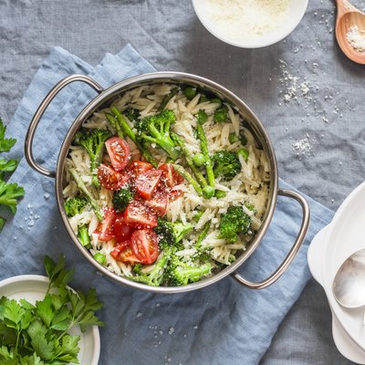 One pot orzo primavera. Orzo pasta with asparagus, broccoli, green peas and cream in a saucepan.