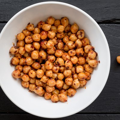 Chickpeas with spice in bowl on black background close up top view image