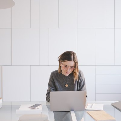 Young female entrepreneur using laptop at desk in workshop