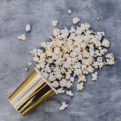 pop corn in golden vase.Grey background