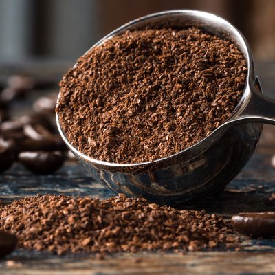 Close-Up Of Ground Coffee In Measuring Cup On Table