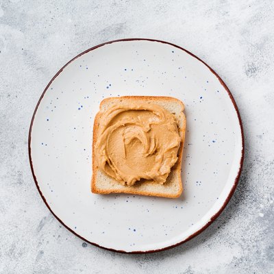 Toast with peanut butter and banana slices on an old gray concrete background. Top view.