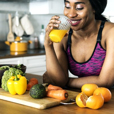 An active woman drinks a homemade electrolyte drink in her kitchen