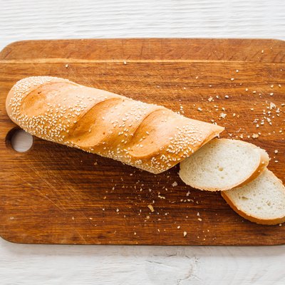 Crusty baguette on wooden board.