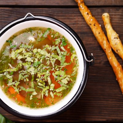 Homemade chicken vegetable soup on wooden table