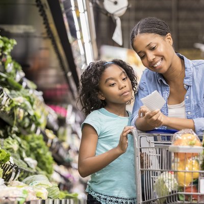 Mother and daughter grocery shop together using list