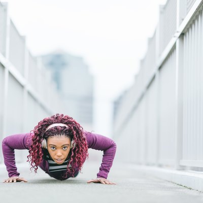 Determined sports woman doing push-ups in city