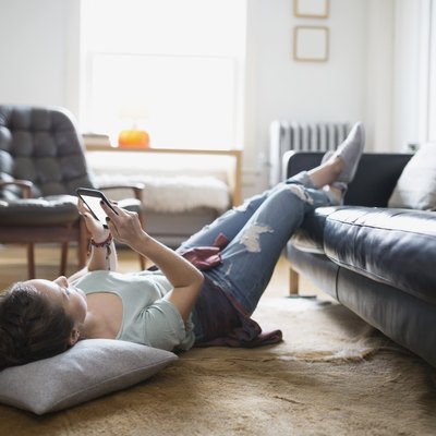 Woman laying with feet up texting cell phone