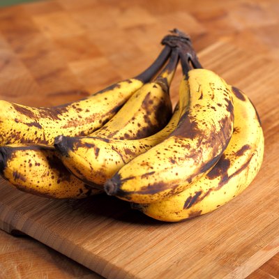 Bunch of overripe bananas on a wooden background