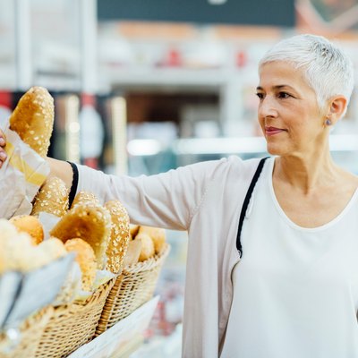 Mature Woman Groceries Shopping for foods for gluten free symbol