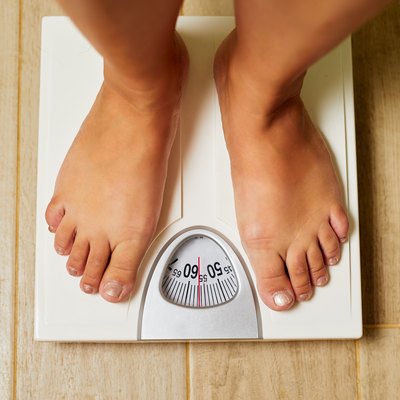 Female bare feet on weight scale in a bathroom