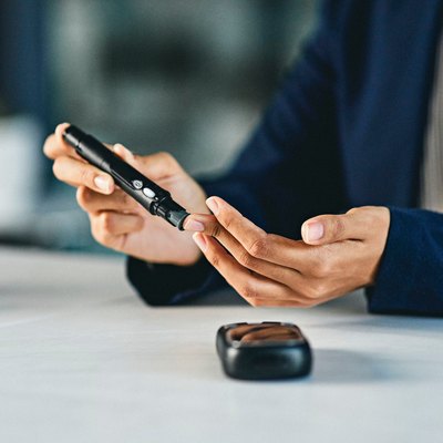 Woman with diabetes checking blood sugar levels to monitor for hyperglycemia over 400