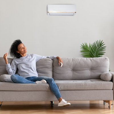 African young relaxed woman sitting on couch breathing fresh air