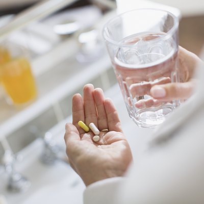 Woman taking vitamins and glass of water