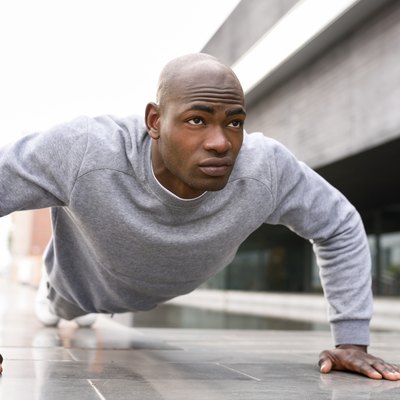 Man Doing Push-Ups On Footpath
