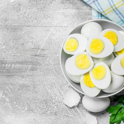 Boiled eggs in a bowl with parsley.