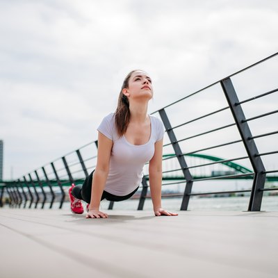 Female athlete doing stretch exercise outdoor.