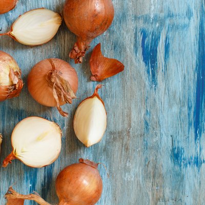 Yellow onions on a blue wooden board