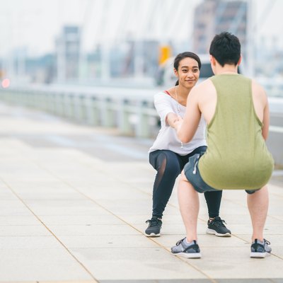 Multi-ethnic young happy couple training in city